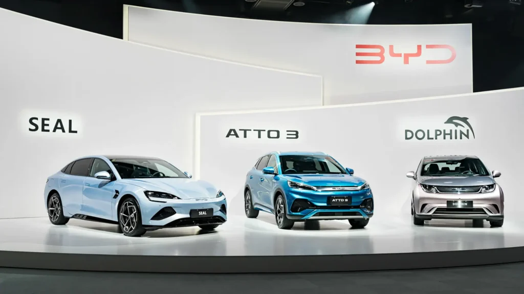 BYD electric vehicle lineup display featuring Seal, Atto 3, and Dolphin models at auto show stage presentation