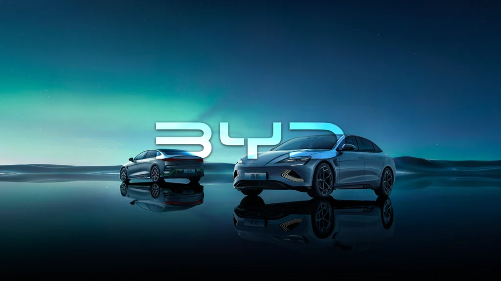 BYD electric sedan models under aurora sky with illuminated BYD logo, showcasing premium new energy vehicles and advanced EV design