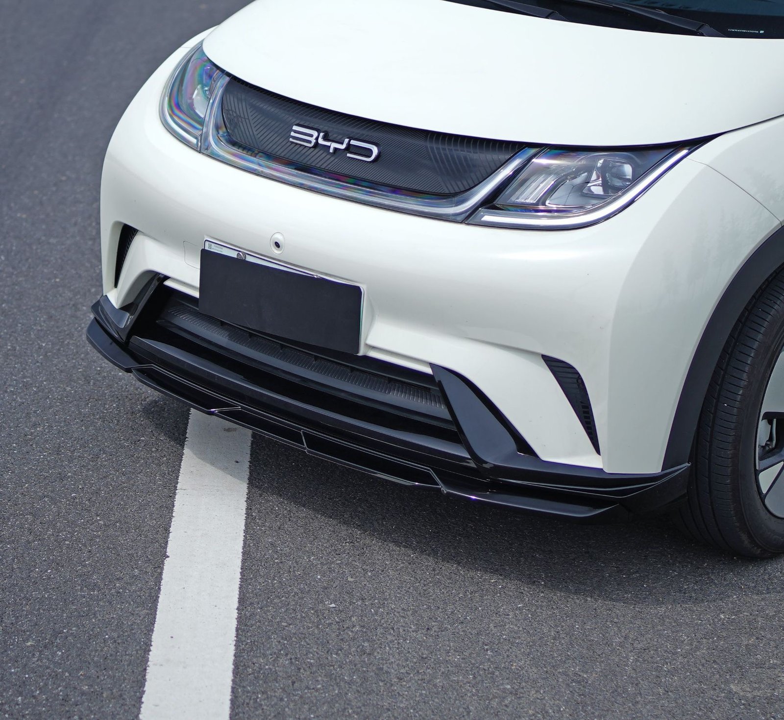 Marvix body kit for BYD Dolphin, low-angle close-up of the front lip fitted to a white BYD Dolphin