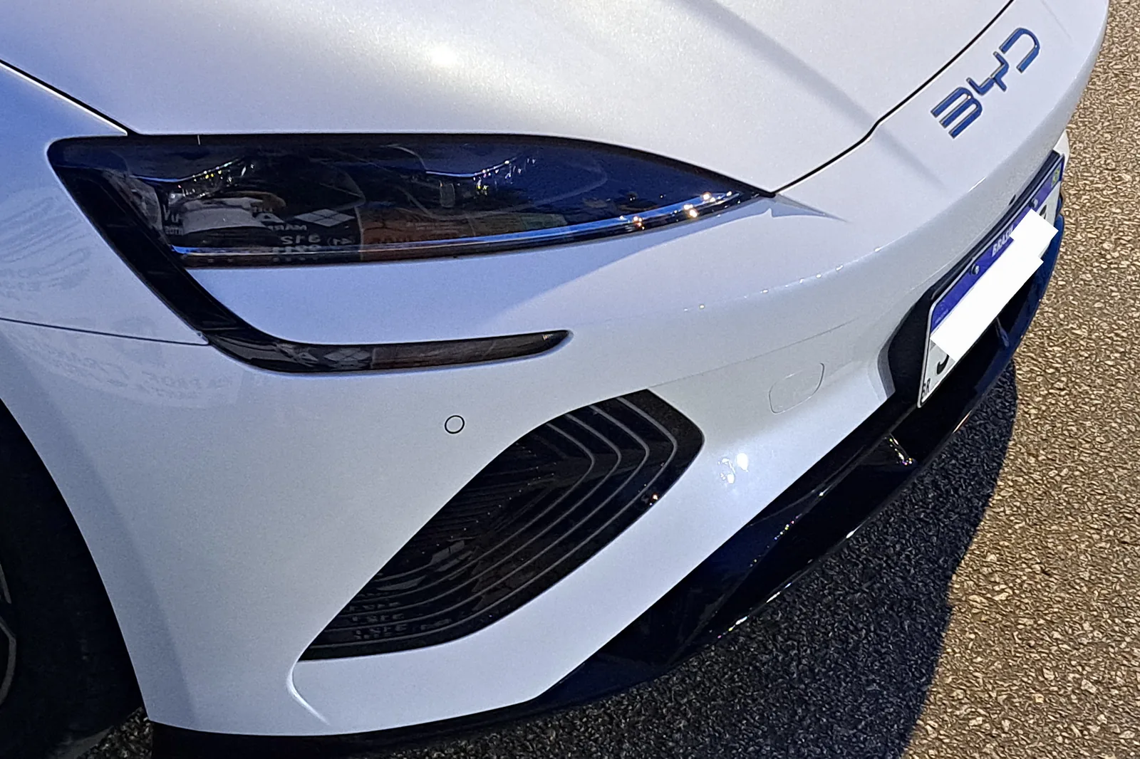 Detalhe da frente do BYD Seal mostrando para-choque e superfícies de sensores