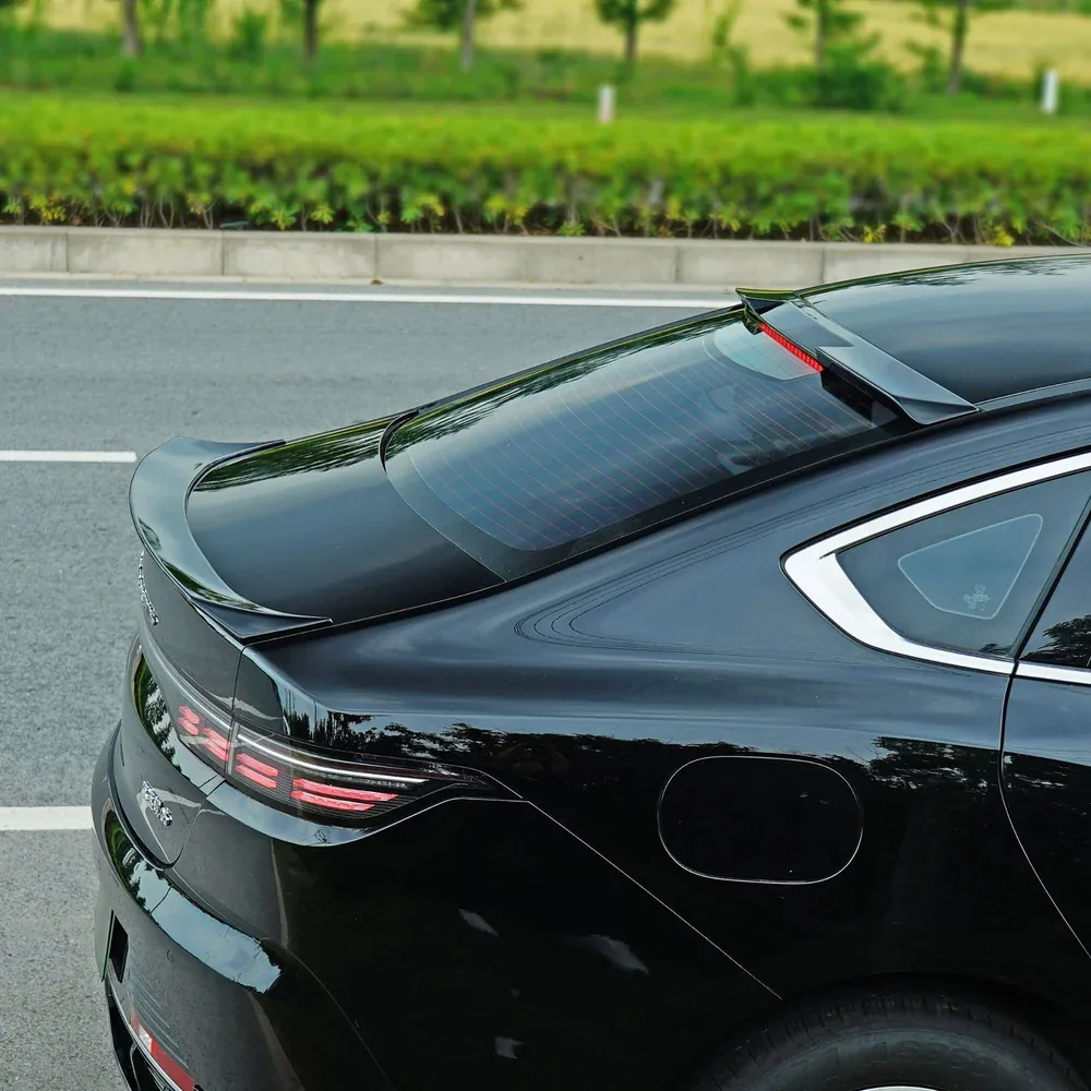 Rear spoiler wing and roof spoiler installed on a BYD King, viewed from the rear angle