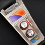 Beige BYD Dolphin lower console storage box in use holding phone