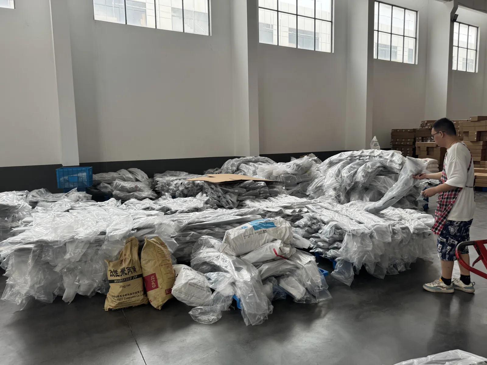 Wrapped plastic exterior parts laid out on the warehouse floor ready for packing and loading